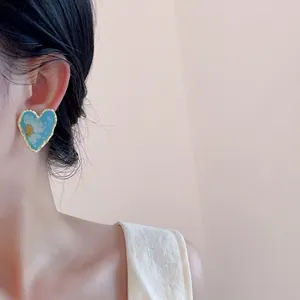 Vintage heart-shaped resin earrings with blue floral patterns and gold foil metal edges