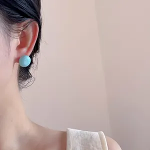 Minimalist light blue round stud earrings shown on model for a trendy daily look