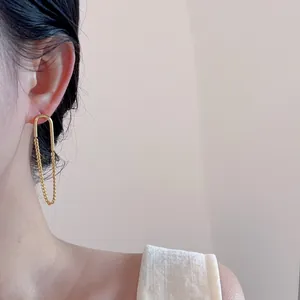 Seitenansicht von eleganten 18k vergoldeten Ohrringen mit Kettendetail an einem Model