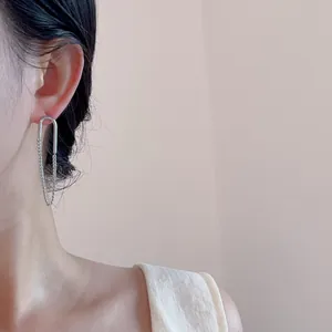 Detail von versilberten Kettenfransen-Ohrringen an einem Modell im modernen U-Design