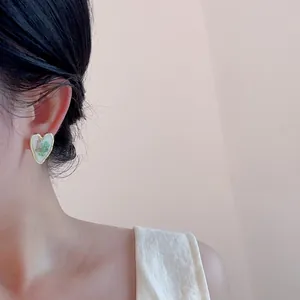 Vintage gold heart earrings with dried flowers on model for elegant garden style