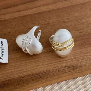 Bagues ovales contrastées au design artistique en or et argent sur bois naturel