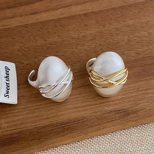 Détail de perles ovales enveloppées dans des lignes entrelacées de fils dorés et argentés