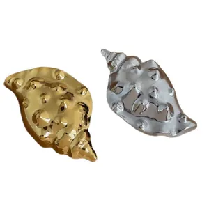 Elegant 18K gold and silver conch shell brooches with realistic metal textures