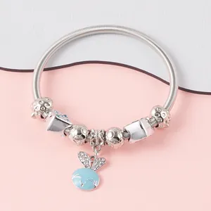 Detailed view of silver charm bracelet with blue enamel rabbit and sparkling crystals