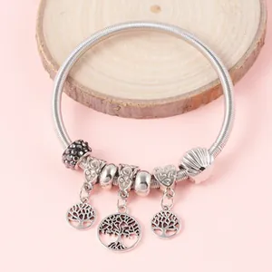 Detail of silver snake chain bracelet with tree of life charms and heart bead