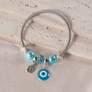 Detailed close-up of beaded bracelet with blue evil eye charm and starfish pendants