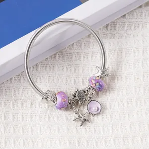 Detailed shot of ocean-themed spring bracelet with purple charms and sea turtle pendants