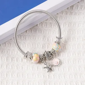 Detail of marine charm bracelet featuring sea turtle, starfish and pink shell pendants