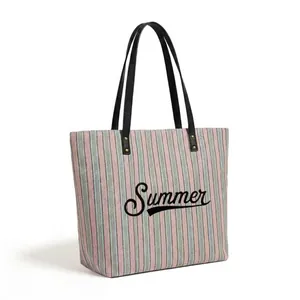 Detail of the large striped beach tote featuring Summer embroidery and reinforced handles