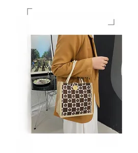 Detail of checkered floral canvas tote bag featuring a wooden button and rope handle