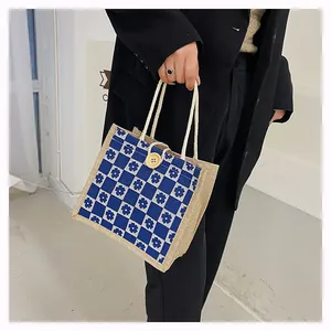 Close-up of canvas bag featuring blue floral checkered pattern and a wooden button closure