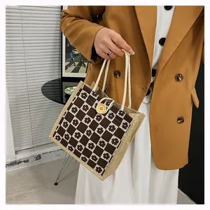 Detail of checkered floral linen handbag with yellow button and woven rope handle
