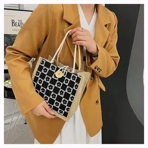 Detail of floral checkered canvas tote bag with rustic hemp handles and yellow button closure