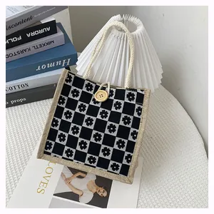 Detail of floral checkerboard canvas tote with woven handles and a round wooden button