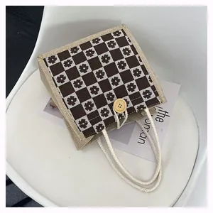 Detail of floral checkerboard canvas tote featuring a rustic wooden button and cotton rope handle