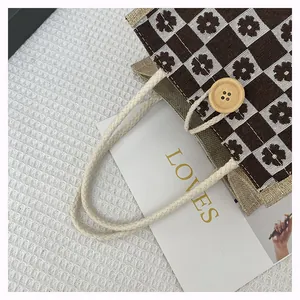 Detailed texture of floral checkerboard canvas bag with wooden button and rope handle