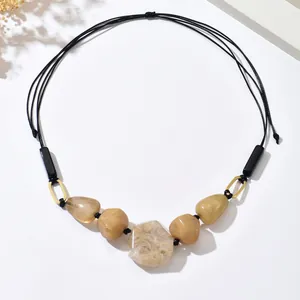 Close-up of vintage bohemian beaded necklace with brown irregular resin stone pendants