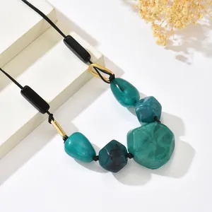 Detail of bohemian necklace with turquoise marble resin beads and gold irregular metal rings