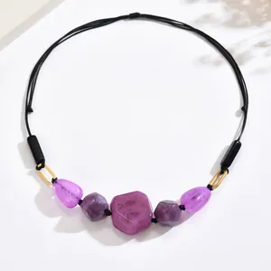 Detail of vintage beaded necklace with purple marble texture beads and golden rings