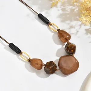Detail of vintage necklace with amber resin beads and gold oval metallic links