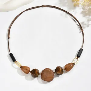 Detail of vintage amber resin beads and gold metal rings on adjustable necklace cord