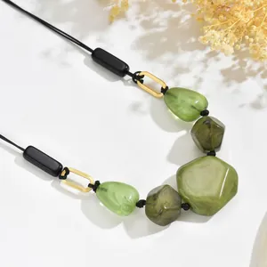 Retro ethnic necklace with green resin marble beads and gold metal links on white base