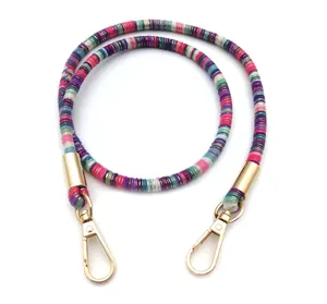 Detail of colorful woven shoulder strap with gold metallic swivel hooks and vibrant texture