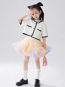 Girl's elegant outfit with off-white tweed cardigan and colorful layered tutu skirt
