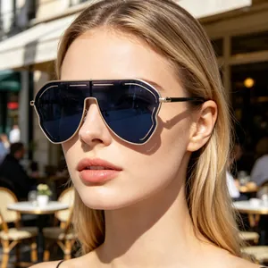 Close-up of oversized square sunglasses with gold metal frames and dark lenses on model