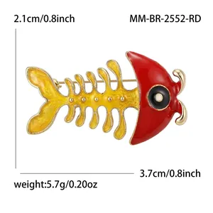 Creative fish bone brooch with red enamel head and yellow skeleton on white background