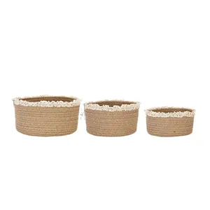 Three-piece set of woven jute storage baskets with white lace trim in various sizes