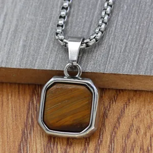 Detail of square stainless steel pendant featuring a brown tiger eye stone and thick chain