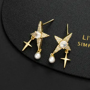 Detailed macro view of gold star earrings with pearl and cross charms on leather