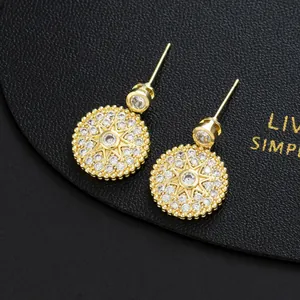 Macro shot of gold starburst drop earrings featuring micro-pave white cubic zirconia