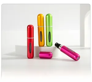 Close-up of matte metal 5ml perfume atomizers with clear windows in four vibrant colors