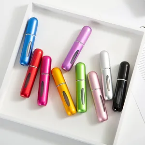 Macro shot of colorful aluminum perfume atomizers with viewing windows in a white tray