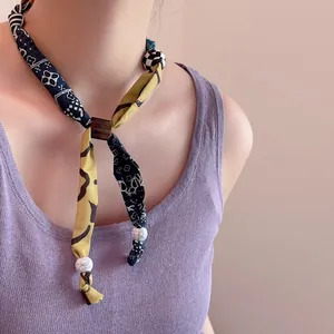 Kleurrijke kralen sjaal ketting met polkadots en vintage bloemenpatroon op model