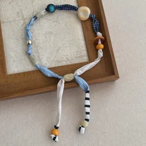 Detail van kleurrijke kralen stoffen sjaal ketting met marmeren hars kralen