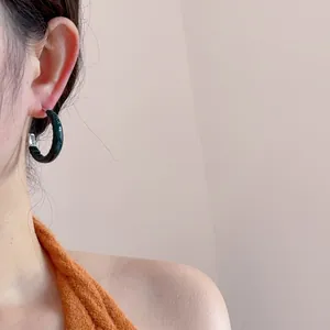 Créoles en C texturées vert foncé avec finition résine rétro portées par un mannequin