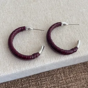 Vue détaillée des boucles d'oreilles en C en cuir bordeaux avec tiges en métal argenté
