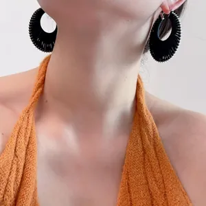 Vue détaillée de créole tressée noire style bohème avec bordure en perles d'argent