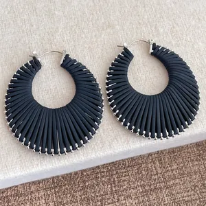 Détail de boucles d'oreilles créoles bohèmes en cordon noir et perles argentées