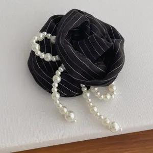 Elegant black striped fabric hair tie with double faux pearl strands in a retro style
