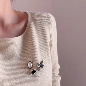 Vintage brooch set with pearls and rhinestones on beige knitwear for elegant styling