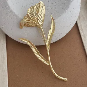 Detailed close-up of a golden tulip flower brooch featuring intricate metallic textures