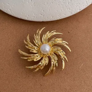 Detail of golden radial fireworks brooch with a central pearl on retro suit accessories
