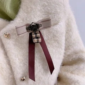 British style vintage bow brooch with brown plaid pattern on a faux fur coat collar