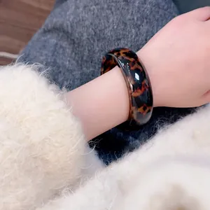 Fashionable leopard print resin wide bangle bracelet with a glossy tortoiseshell finish
