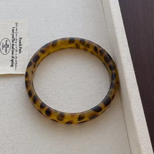 Detailed macro view of vintage leopard print resin bangle with polished amber finish